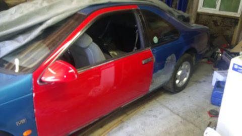 1994 Ford Thunderbird - This car has a red front door and a blue rear door, suggesting bodywork is in progress.