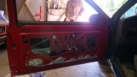 1994 Ford Thunderbird - The interior of a 1994 Ford Thunderbird, showing the red door panel removed for repairs.