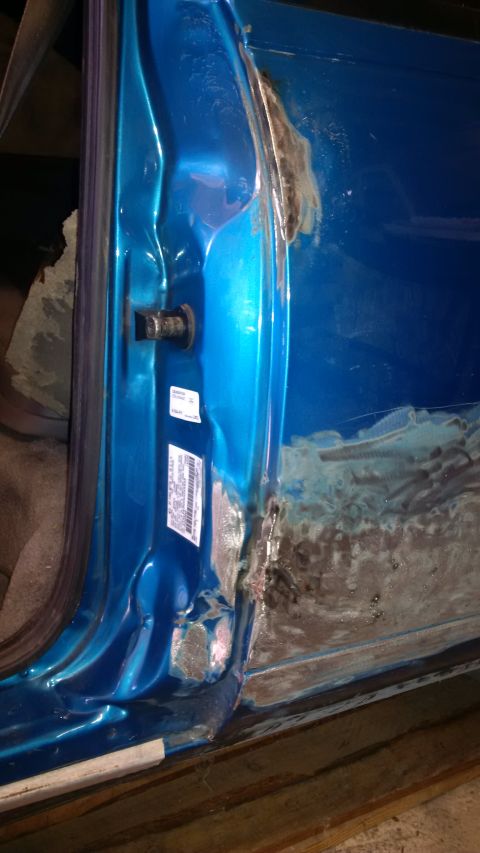 1994 Ford Thunderbird - Close-up of a car door's interior showing signs of rust and body repair.