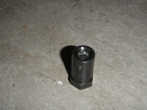 1961 International Scout 800 - A close-up view of a black metal socket wrench adapter, resting on a concrete surface.