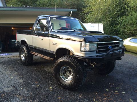 1989 Ford Bronco - This lifted Ford Bronco features a two-tone paint scheme and aggressive off-road tires.