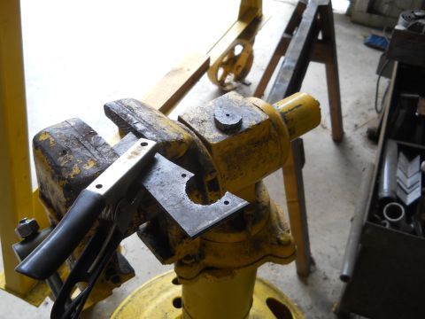 1992 Ford Bronco - Metal plate being cut in a vise with pliers, part of a workshop scene.