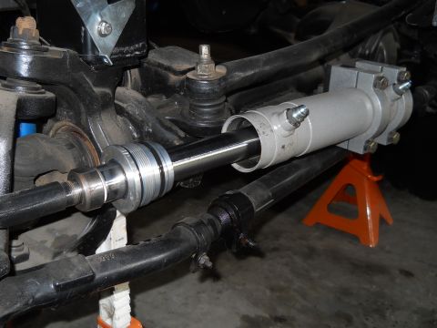 1992 Ford Bronco - This image shows a close-up view of a power steering cylinder installation on a vehicle's steering system.