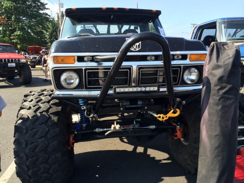 1989 Ford Bronco - This heavily modified Ford truck features oversized tires and a prominent front brush guard with an LED light bar.