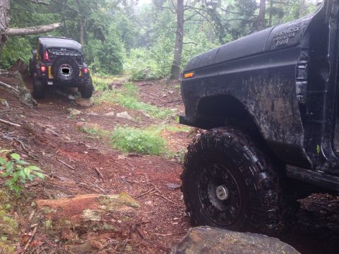 1979 Ford Bronco - A black 1978 Ford Bronco navigates a muddy trail, with another off-road vehicle ahead.