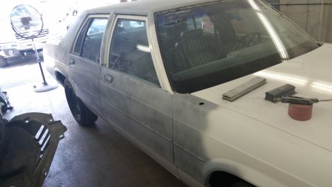 1991 Ford LTD Crown Victoria - A sedan is being prepped for paint in a workshop.