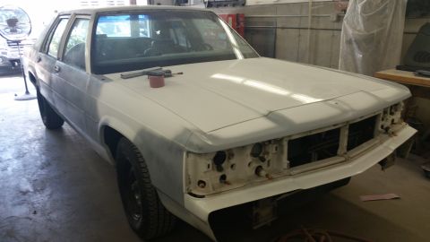 1991 Ford LTD Crown Victoria - A 1991 Ford Crown Victoria LTD is shown in a garage, undergoing repairs with its front end disassembled.