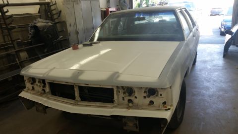 1991 Ford LTD Crown Victoria - This car is undergoing bodywork in a garage, with tools on the hood.