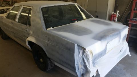 1991 Ford LTD Crown Victoria - This sedan is in a workshop, prepped for paint with primer and masking tape.