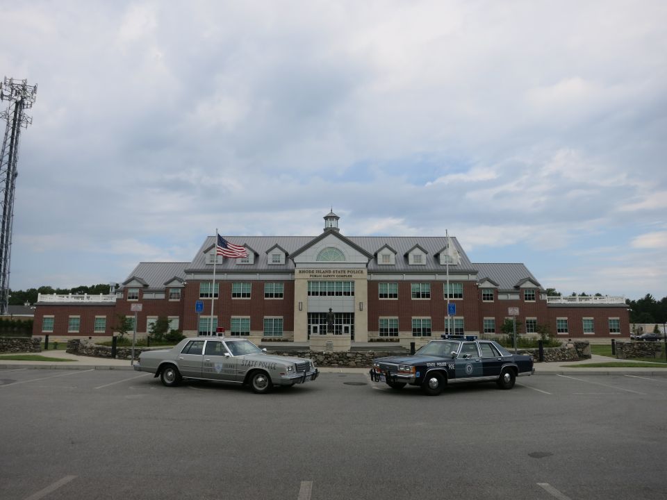 Silver and blue police sedans parked together at Rhode Island State Police complex