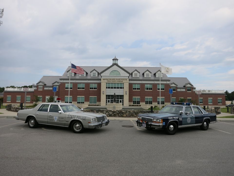 Silver and blue State Police sedans parked in lot at Rhode Island State Police