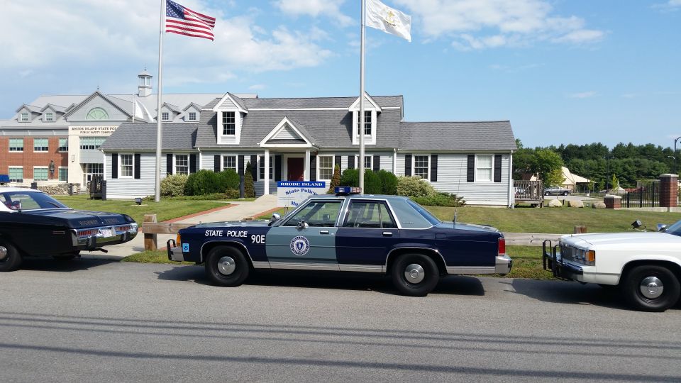 Blue State Police 90E sedan in a line of vehicles at State Police Museum