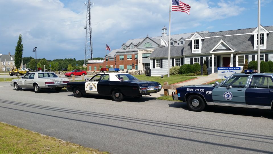 Lineup of police cars including black-and-white and blue 90E at State Police Museum