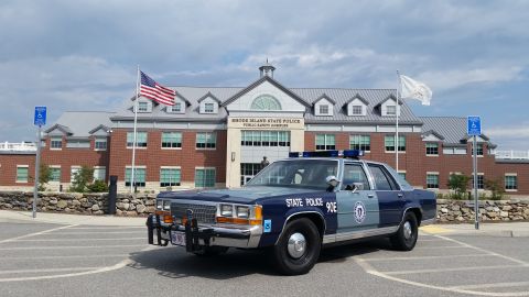 1991 Ford LTD Crown Victoria - A vintage Rhode Island State Police car is parked outside the Public Safety Complex building.