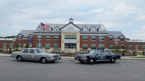 1991 Ford LTD Crown Victoria - Two vintage Rhode Island State Police cruisers are parked outside the Public Safety Complex.