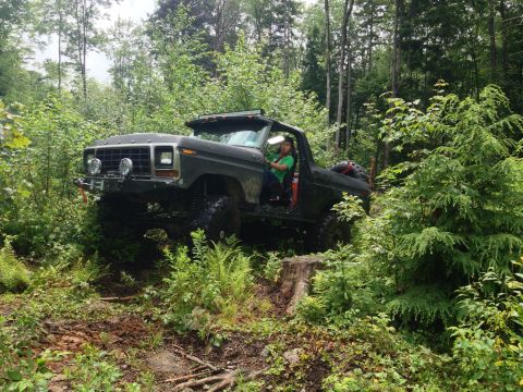 1979 Ford Bronco - This modified 1978 Ford Bronco navigates a challenging wooded terrain with its driver at the wheel.