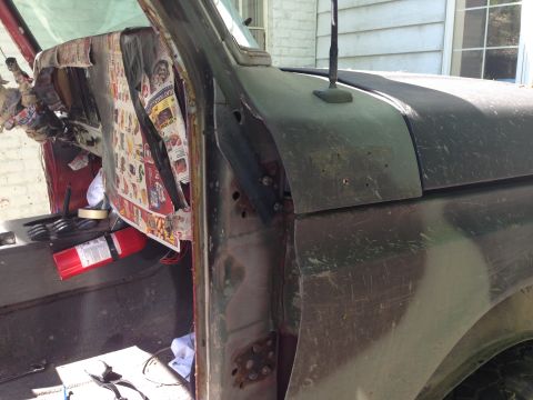 1979 Ford Bronco - The interior of an old truck shows damage and is covered with newspaper, with a fire extinguisher visible.