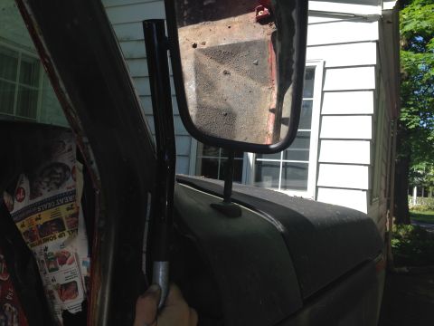 1979 Ford Bronco - Close-up view of a vehicle's side mirror and interior door panel.