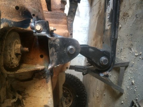 1994 Ford Bronco - Detail of a vehicle's suspension system, showing a bracket and linkage, with a tire in the background.