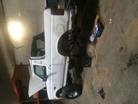 1994 Ford Bronco - White pickup truck in a garage, hood is open. Likely a 1992 Ford F-Series.