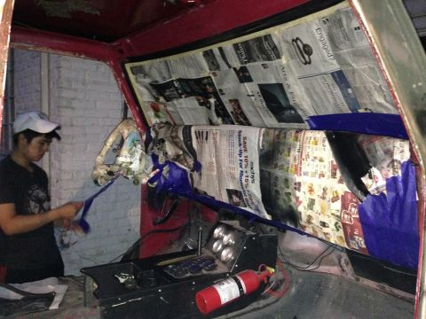 1979 Ford Bronco - A person works on the interior of a red vehicle, using newspaper for protection during what appears to be a painting preparation.