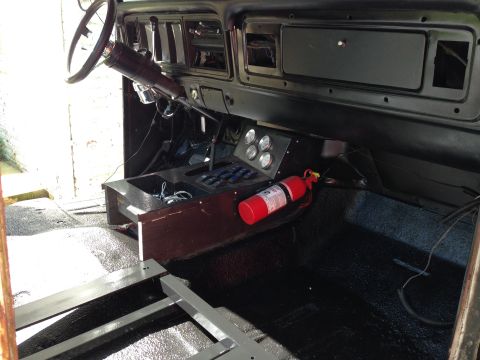 1979 Ford Bronco - The interior of a 1978 Ford Bronco shows a wooden center console with gauges and a fire extinguisher.