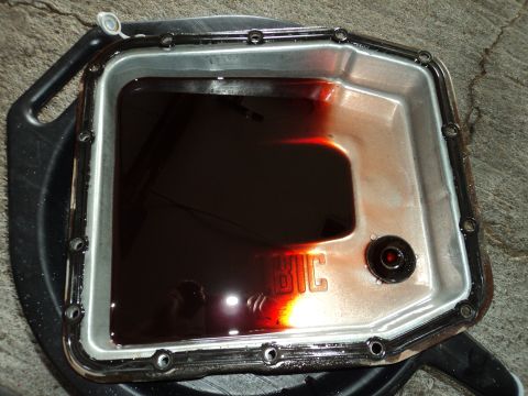 2004 Mercury Grand Marquis - The transmission pan contains dark, used fluid, indicating a need for service.