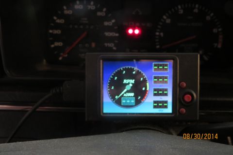 1985 Volkswagen GTI - A digital gauge displays RPM and other vehicle data, with the original speedometer and tachometer in the background.