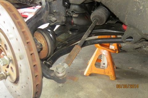 1985 Volkswagen GTI - Car's front suspension components, including brake rotor and tie rod, are visible with the vehicle on a jack stand.