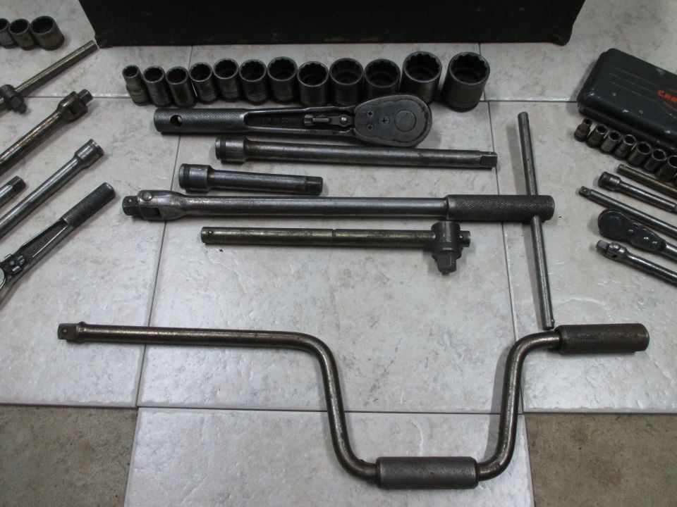Tool set with sockets, ratchets, and extensions on a tiled surface