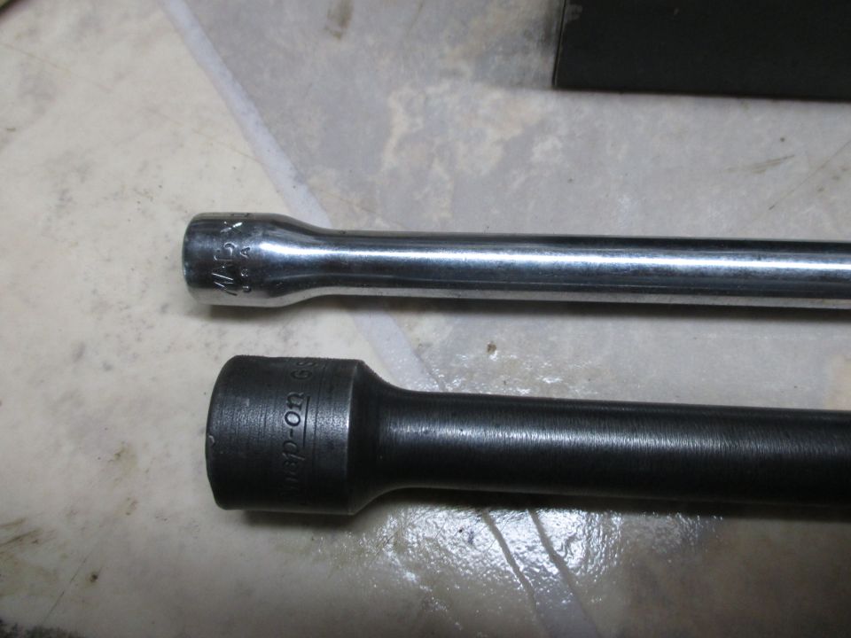 Two socket extension bars, one chrome with markings, one black with 'Snap-On' visible