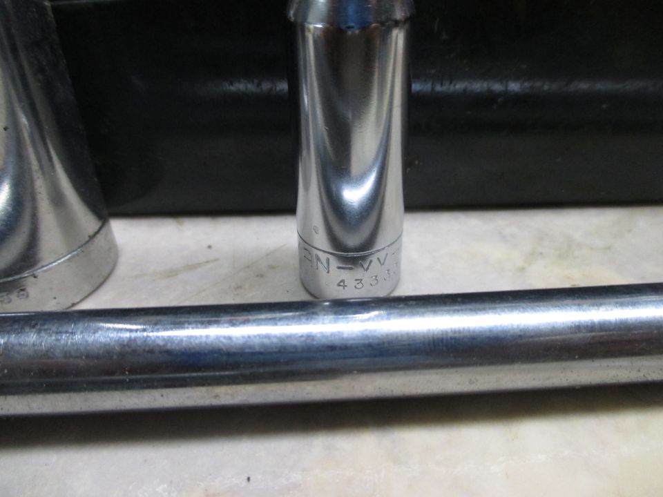 Close-up of socket wrench extensions and a socket with markings 'EN=VV' and '4333'