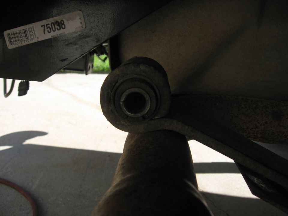 Leaf spring bushing on a vehicle part with a sticker showing '75038'