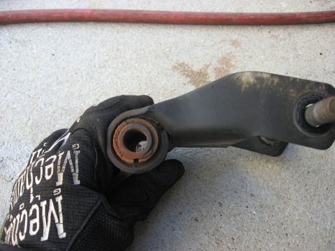 1994 Ford Bronco - Close-up of a worn leaf spring bushing being held by a gloved hand.