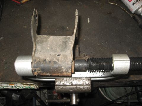 1994 Ford Bronco - A tool is used to remove a leaf spring bushing, held securely in a vise.