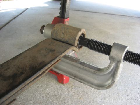 1994 Ford Bronco - Using a C-clamp to remove a leaf spring bushing, supported by a jack stand.