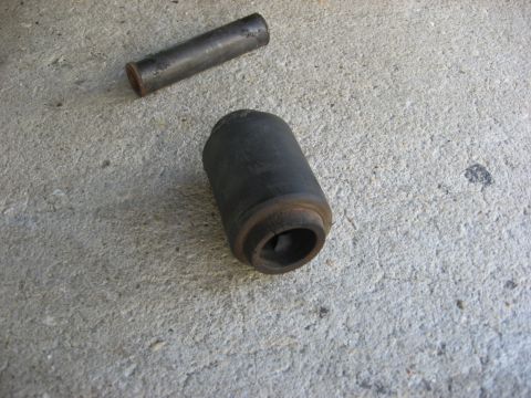 1994 Ford Bronco - A worn leaf spring bushing and its metal sleeve are shown resting on a concrete surface.