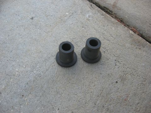 1994 Ford Bronco - Two new leaf spring bushings are shown on a concrete surface.