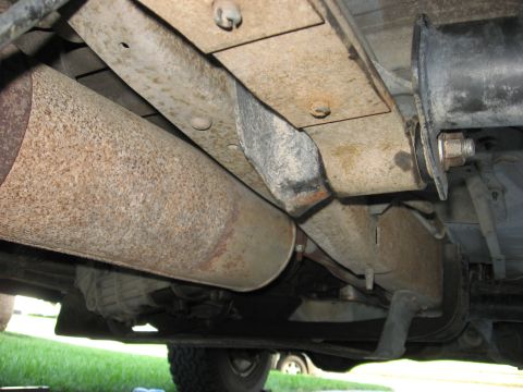 1994 Ford Bronco - Underside view of a 1994 Ford Bronco, focusing on the leaf spring bushings and exhaust components.