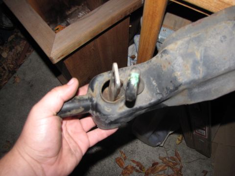 1992 Ford F-150 - Close-up of a vehicle suspension component being held by a hand.