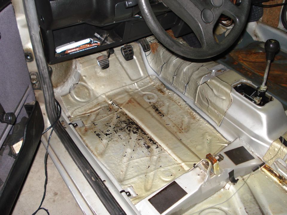 1985 Volkswagen GTI interior floor with sound deadening removed, showing pedals and shifter