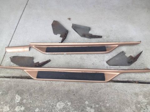 1993 Ford Bronco - These running boards and their mounting brackets are laid out on a concrete surface.