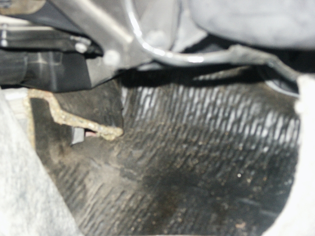 car's passenger side floor mat and some undercarriage components