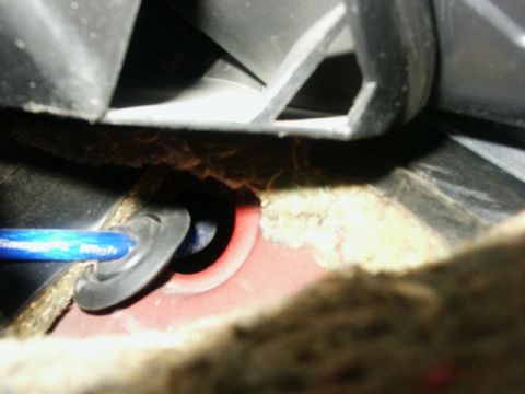 1998 Mercury Sable - Interior view shows a wire being routed through a grommet in the car's body.