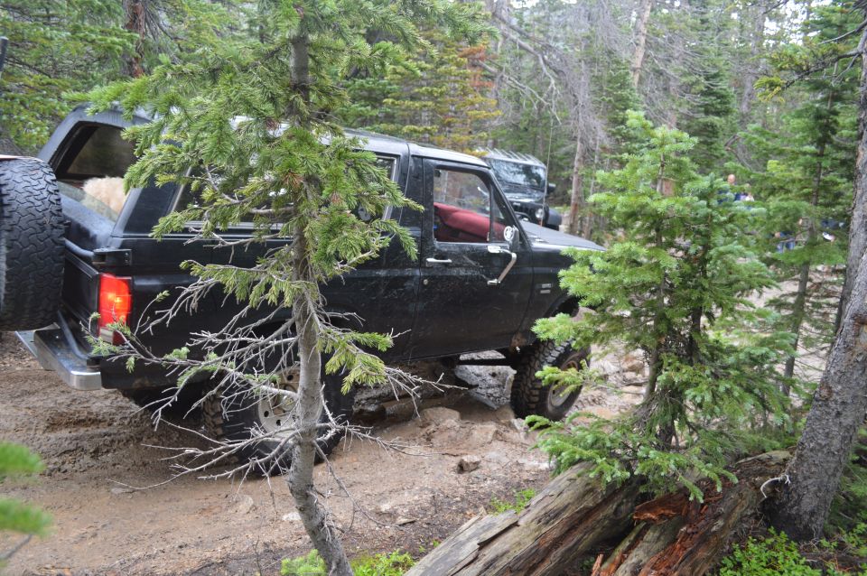 Black SUV navigating rocky trail, another SUV visible behind it