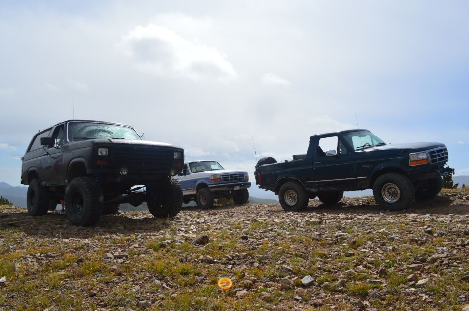 Dark blue 1992 Ford Bronco with removable top, 3/4 front view, on a rocky hill