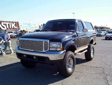 1988 Ford Bronco - This Ford Bronco features a prominent chrome grille and lifted suspension.