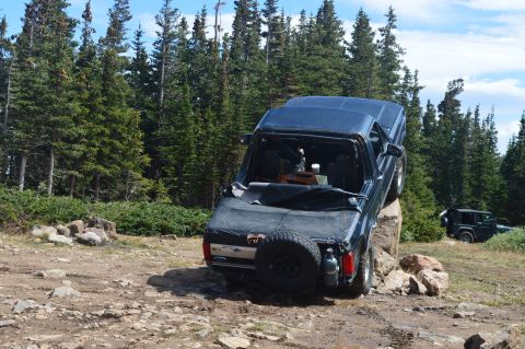 1983 Ford Bronco - This 1980s Ford Bronco is precariously balanced on a rock during an off-road excursion.
