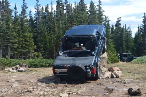 1983 Ford Bronco - Ford Bronco navigating a large rock obstacle on a trail with another Jeep nearby.