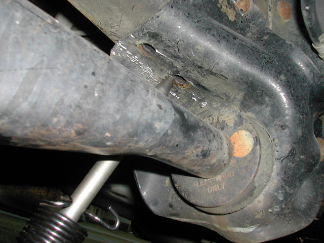 Underside view of vehicle front axle housing, control arm and coil spring